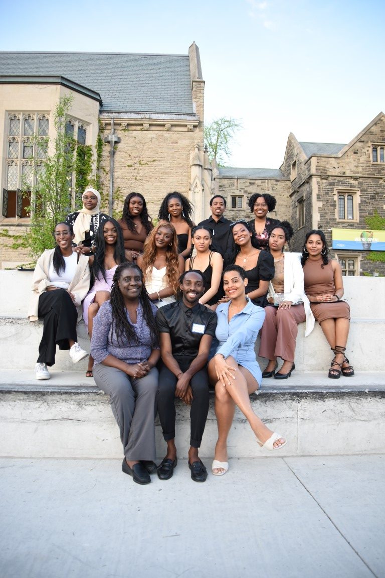 Group of black student leaders from a leadership recognition event gathered outside for a photo on campus