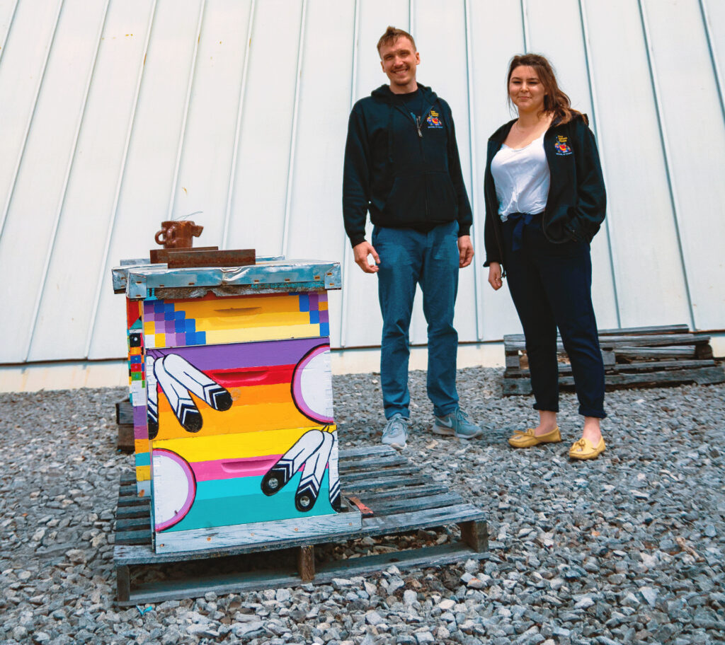 Two indigenous students pictured by the bee hive on top of First Nations House