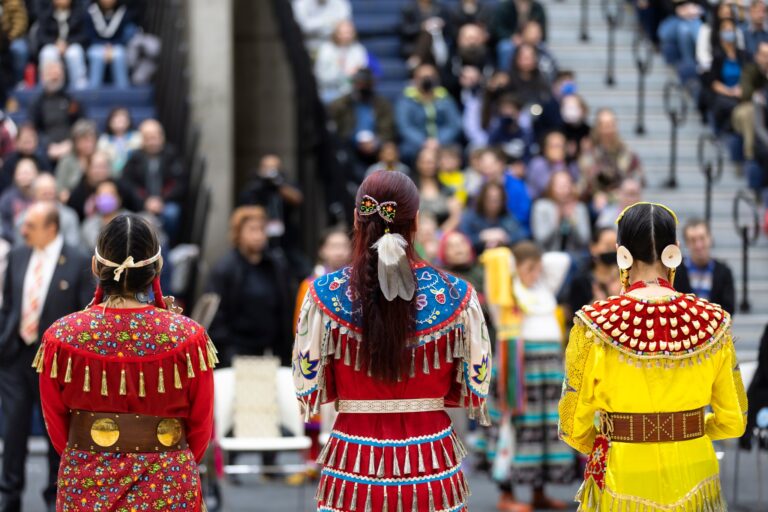 Three dancers with their backs to the camera perform during the inaugural All-Nations Powwow.