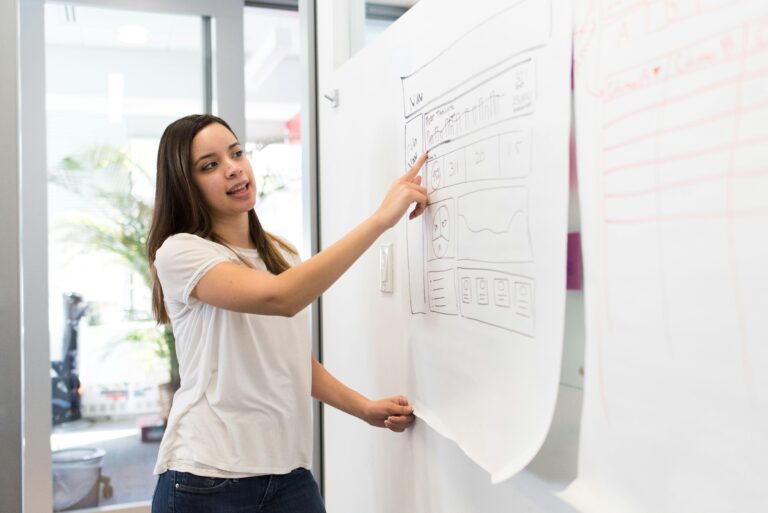 A young person points to a sketch on a whiteboard