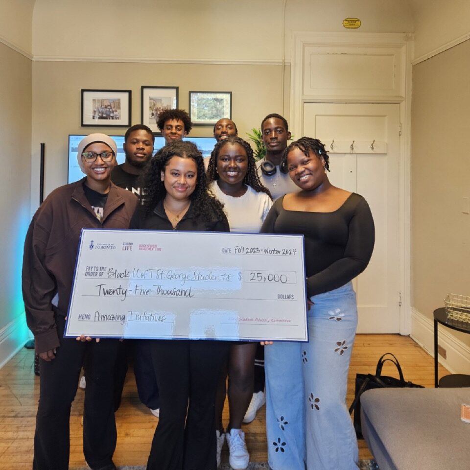 Group of students holding up a large cheque