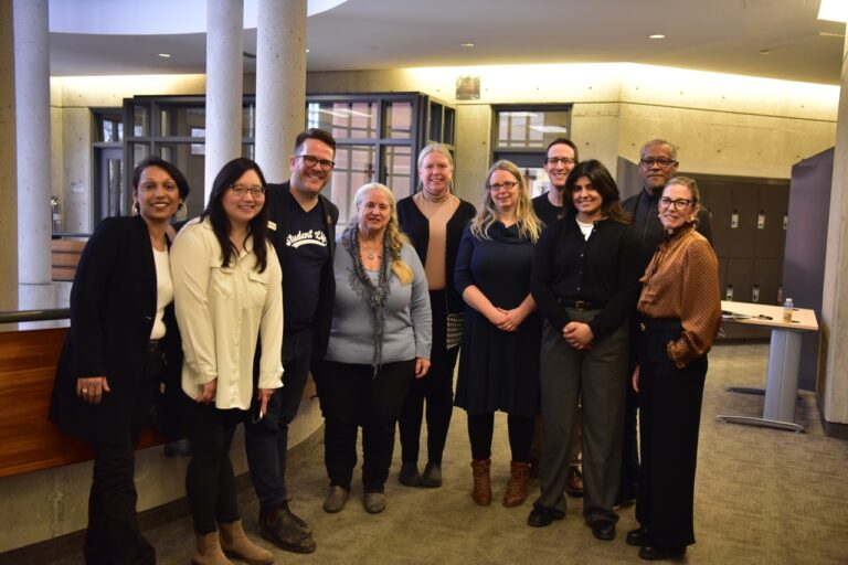 Group of people standing and looking at the camera in foyer