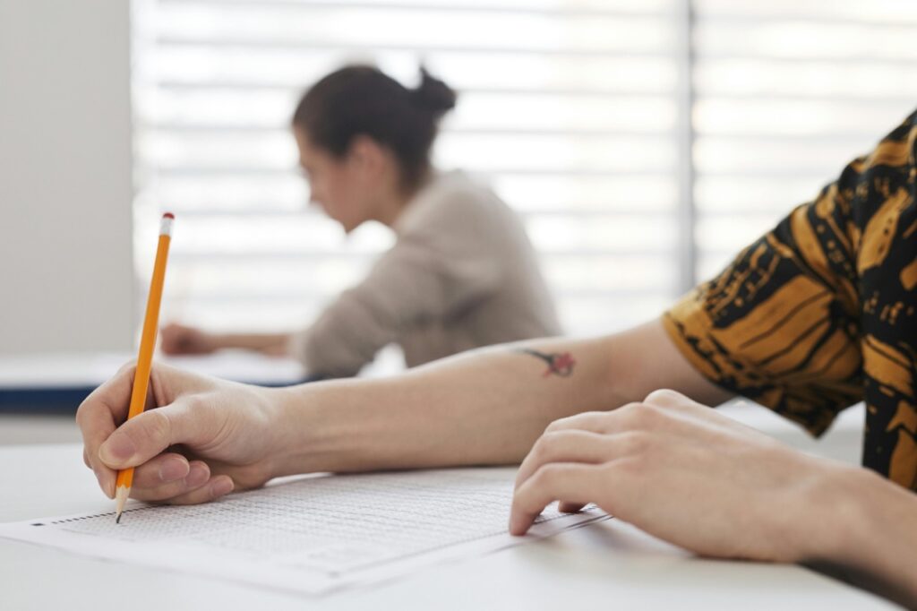 Hand holding pencil writing a test